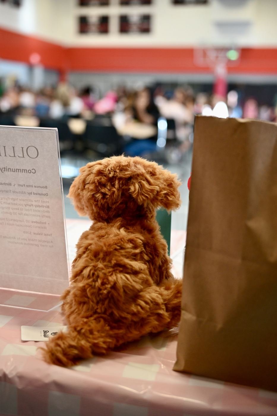 A friendly dog sits beside a table at the benefit