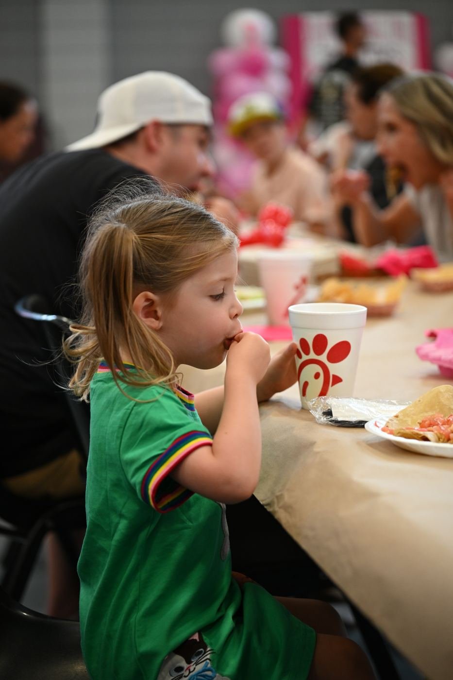 A young girl enjoys her dinner at the event