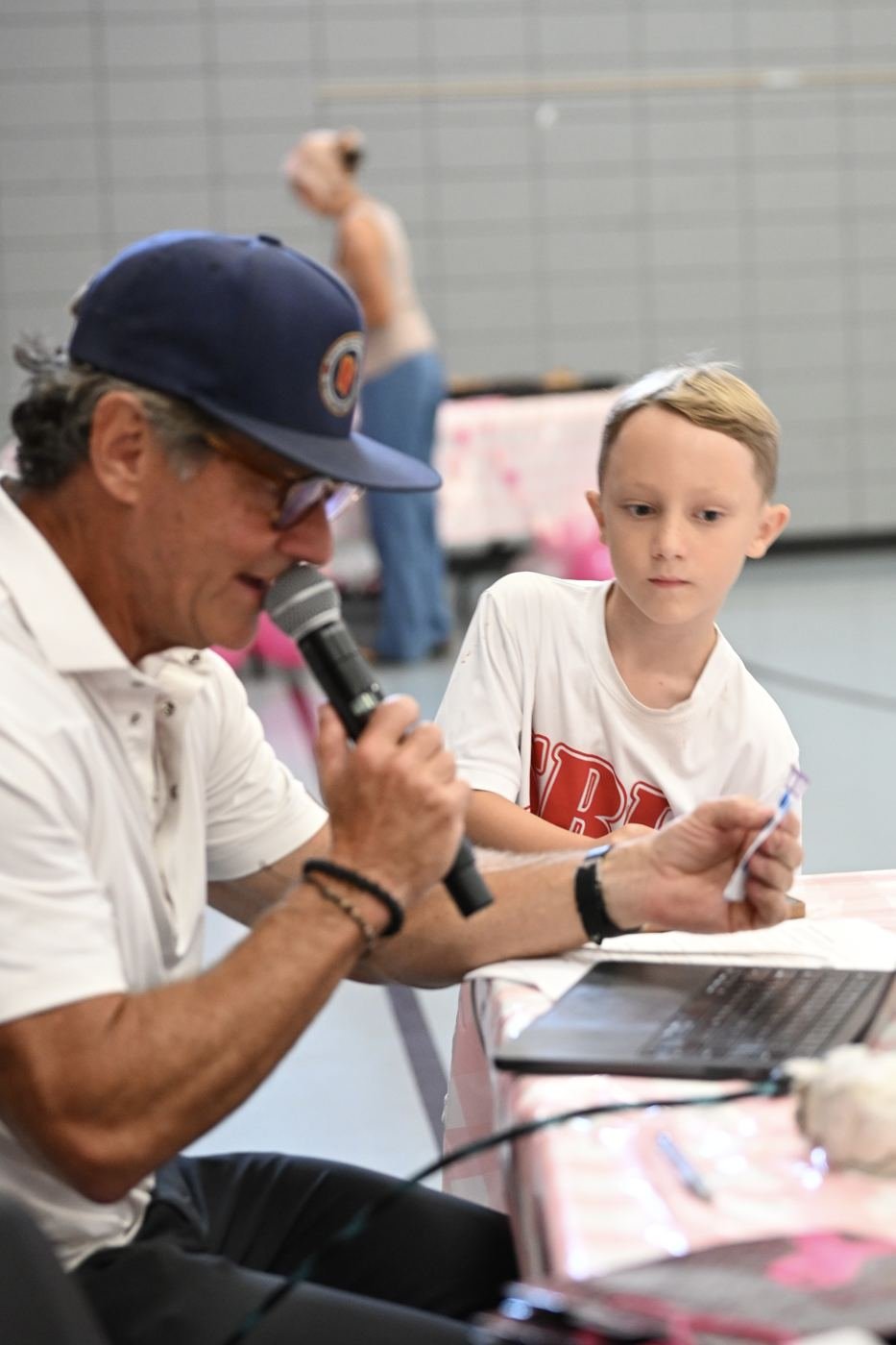 The emcee calls bingo numbers alongside a young helper