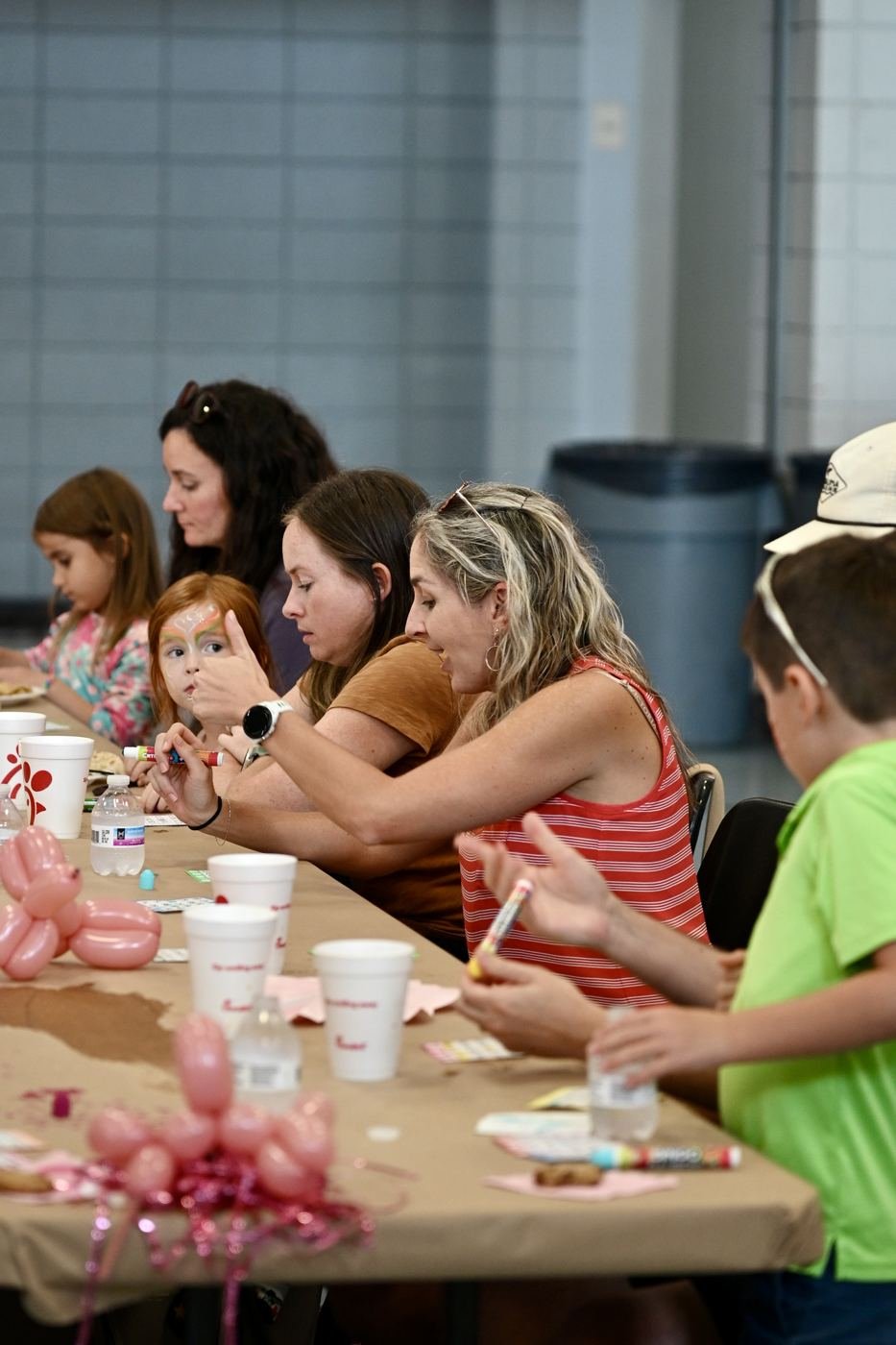 Kids and parents work on a craft at the table