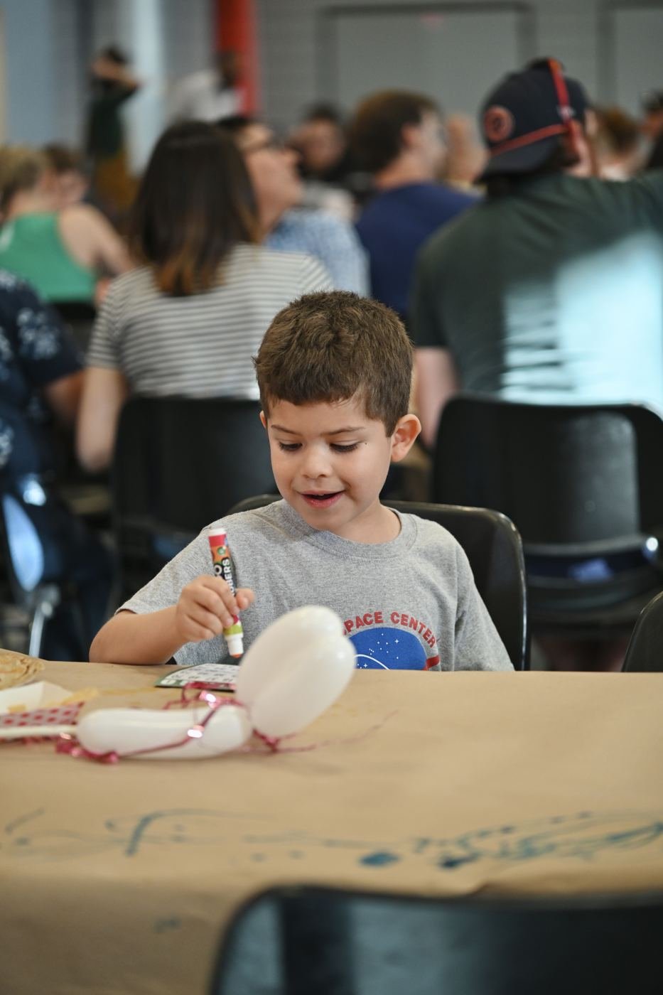A boy decorates a craft during camp-style activities