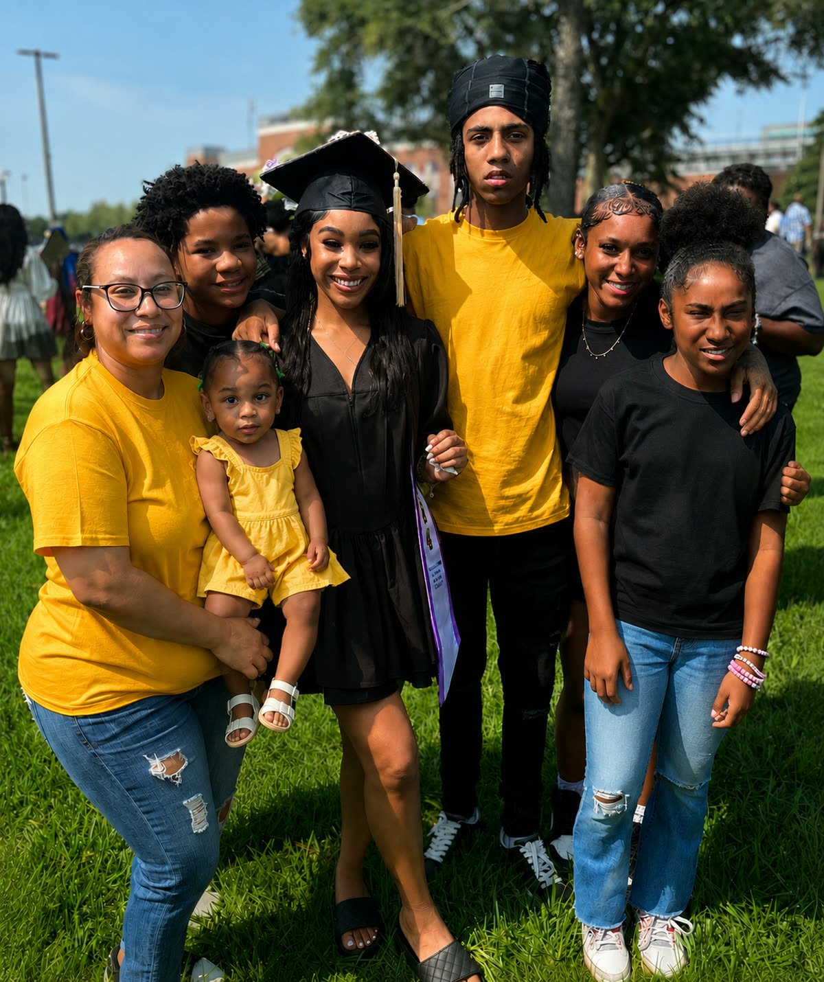Crystal Johnson with her family outdoors at a graduation celebration