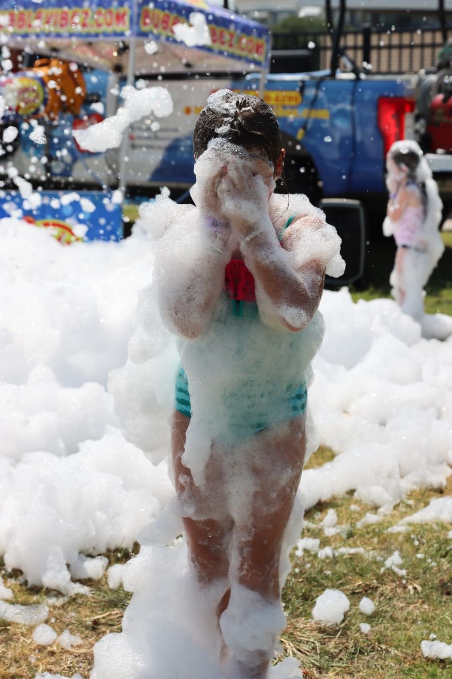 A camper laughing while covered in bubbles at a foam party