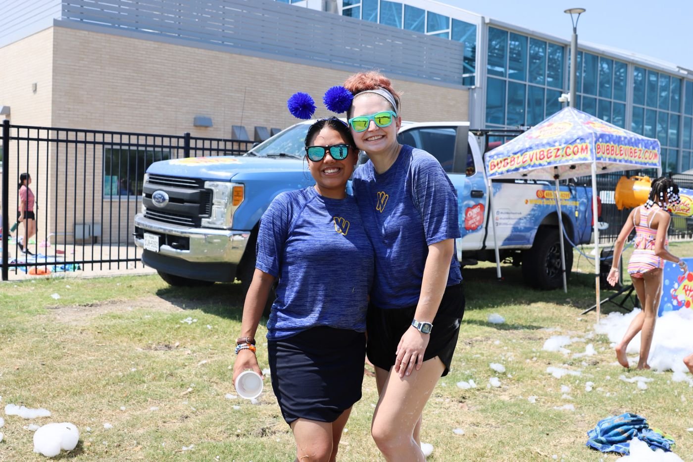 Two camp staff members smiling together during a foam party
