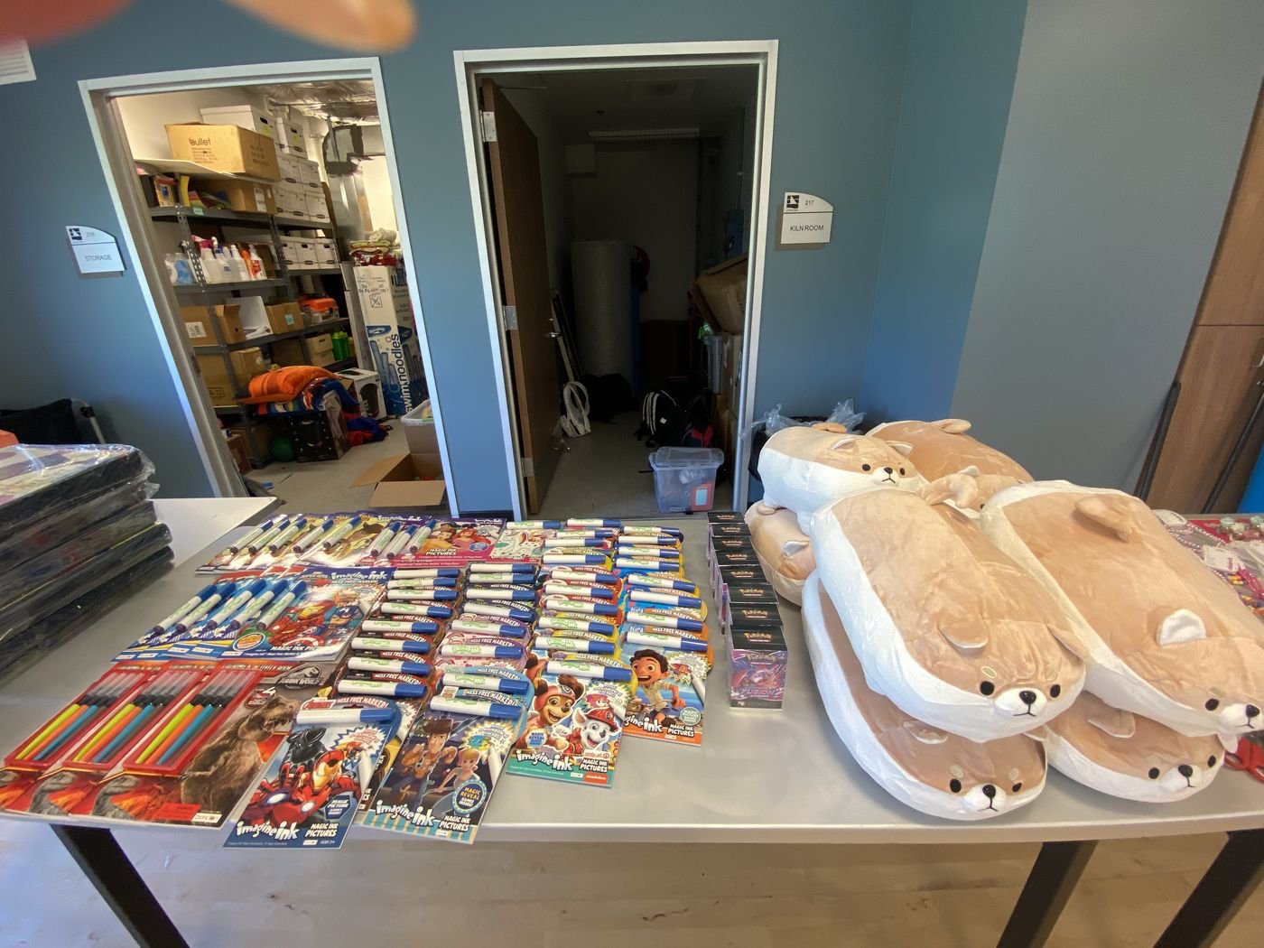 Art supplies, activity books, and plush toys set out for campers